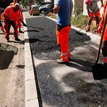 Kézi aszfaltbeépítés szegély mellett, gereblyével és lapáttal